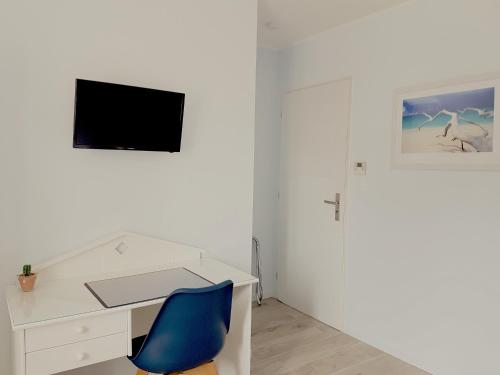 a white desk with a blue chair in a room at Villa Géna in Saint-Médard-dʼEyrans