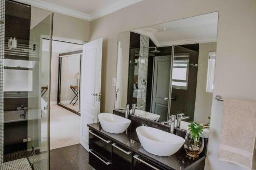 a bathroom with two sinks and a large mirror at Franschhoek Village House in Franschhoek