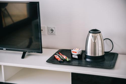 a tea kettle on a black tray next to a monitor at Casa Bianca & Spa in Ulcinj