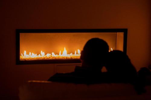 a person sitting in front of a fireplace at El Castell de la Pobla de Lillet (Adults Only) in La Pobla de Lillet