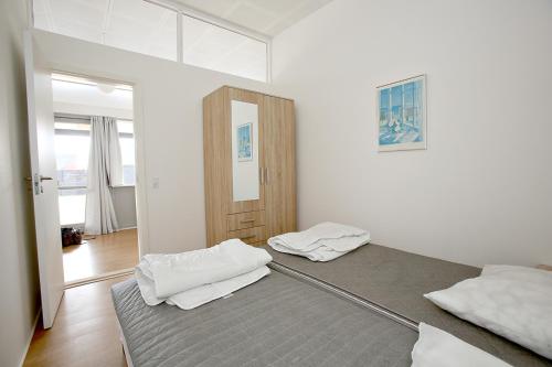 two beds in a room with white walls at Skagenbnb in Skagen