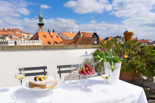 a table with a cake and glasses of wine at Boutique Apartments U Rolanda in Znojmo