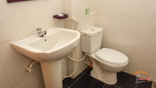 a bathroom with a white toilet and a sink at Gamagedara Resort in Dambulla