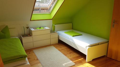 a small green room with a bed and a window at Ferienhaus am Löffelberghüttchen in Gießübel
