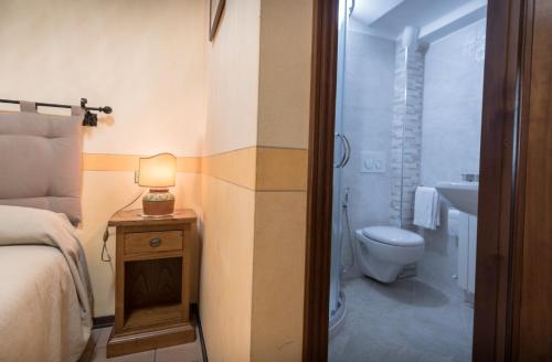 a bedroom with a bed and a bathroom with a toilet at La Piaggia in Assisi