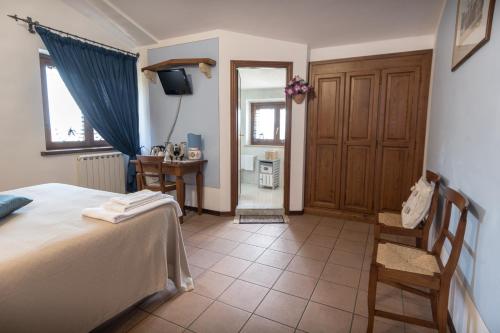 a bedroom with a bed and a desk and a television at La Piaggia in Assisi