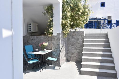 a patio with a table and chairs and stairs at Adelphi Apartments in Perissa