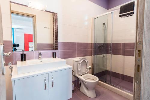 a bathroom with a toilet and a sink and a shower at Adelphi Apartments in Perissa