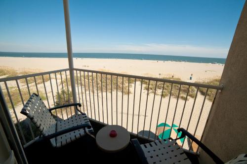 a balcony with two chairs and a beach at DeSoto Beach Hotel in Tybee Island