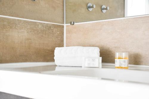 La salle de bains est pourvue d'une baignoire blanche et d'un miroir. dans l'établissement Hotel l'Europe - Cholet Gare, à Cholet