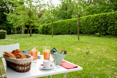 サン・グレゴワールにあるChic Appartement avec Terrasse, Parking Privatifのテーブル(パンとドリンクのバスケット付)