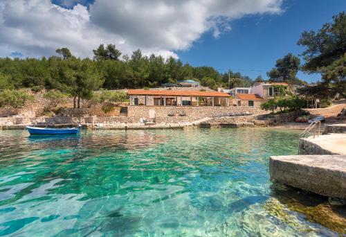 a house in the middle of a body of water at Golden Bay Hvar in Hvar