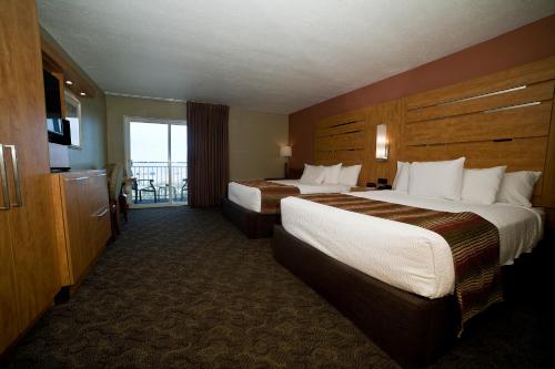 a hotel room with two beds and a balcony at DeSoto Beach Hotel in Tybee Island
