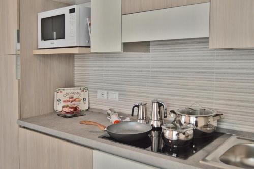 a kitchen counter with a stove with pots and pans at Casa Comisso in Caorle
