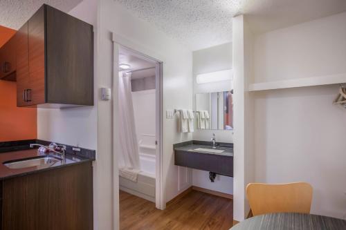 a bathroom with a sink and a mirror at Motel Bo-Camrose, AB in Camrose