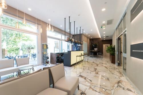 a lobby with a marble floor and chairs at Hotel Milano Castello in Milan
