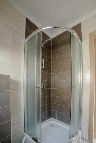a shower with a glass door in a bathroom at Amber Playa in Dębki