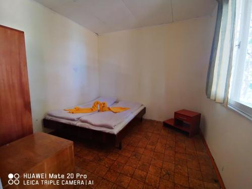 a small bedroom with a bed with an orange ribbon on it at Letovishte Romantika in Kamchia