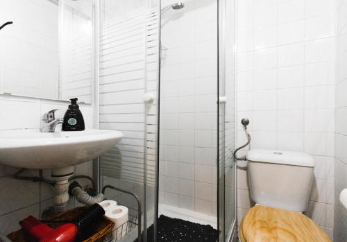 a bathroom with a toilet and a sink and a shower at Camões Lofty Boho Apartment in Setúbal