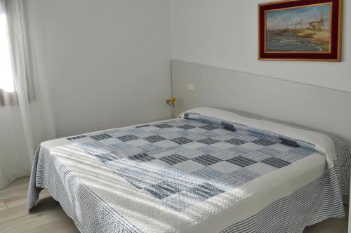 a bed in a room with a picture on the wall at Casa Comisso in Caorle