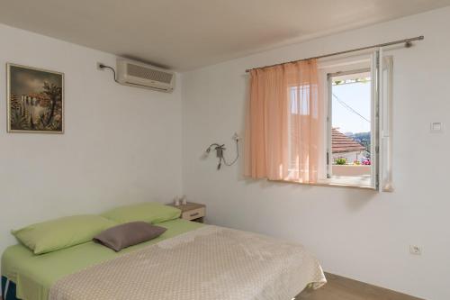 a bedroom with a green bed and a window at Apartment Meet & Greet in Dubrovnik