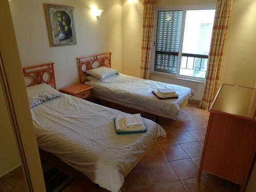 Una habitación de hotel con dos camas y una ventana. en One Bedroom Apartment with Stunning Views, en Alvor