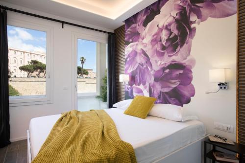 a bedroom with a bed with a flower mural on the wall at Vista Suites - Piazza Yenne in Cagliari