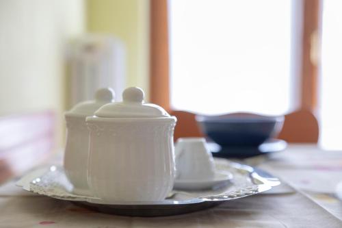 a white tea pot on a plate on a table at B&B NONNO MICHELE in Fisciano