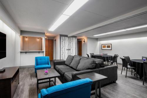 a living room with a couch and tables and chairs at Valhalla Hotel & Conference Centre in Thunder Bay