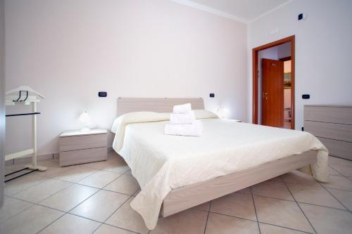 a white bedroom with a large bed with two towels on it at B&B NONNO MICHELE in Fisciano