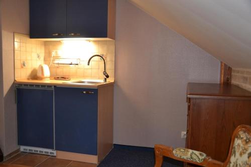 a small kitchen with a sink and a counter at Penzion Aurooms in Zlatníky