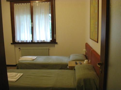 a room with two beds and a window at LORELY in Udine