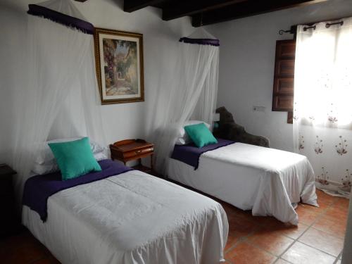 古羅的住宿－Casa del Limonero，一间卧室设有两张床和窗户。