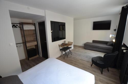 um quarto de hotel com uma cama e um sofá em Hotel De Quebec em Rouen