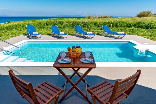 a table and chairs next to a swimming pool at Diagoras & Attalos Villas in Fánai