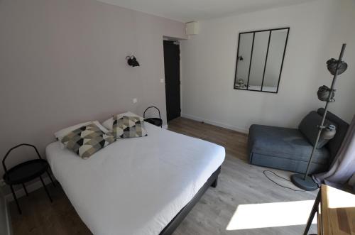 a small bedroom with a bed and a chair at Hotel De Quebec in Rouen