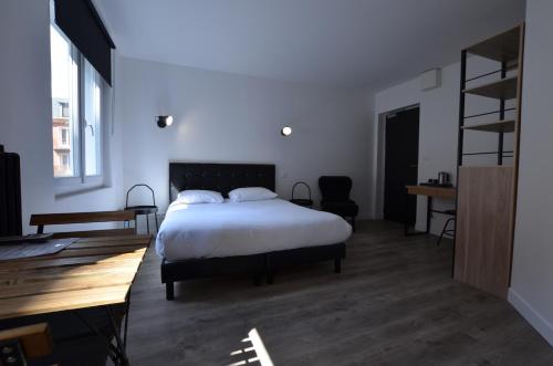 a bedroom with a bed and a desk and a ladder at Hotel De Quebec in Rouen