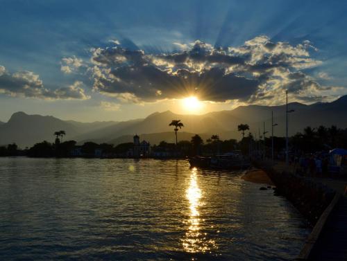 a sunset over a river with mountains in the background at Casa Simone Pousada in Paraty