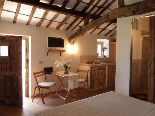 a living room with a table and a kitchen at Agriturismo Sa Mendhula in Cugnana