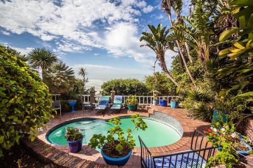 una piscina con plantas y un patio en A Heavenly View, en Muizenberg