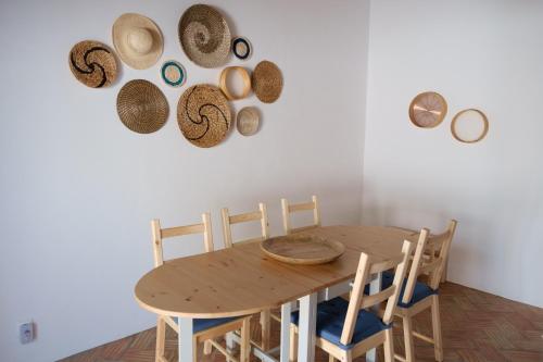 a dining room with a wooden table and straw hats on the wall at Casas de Mértola 29 in Mértola
