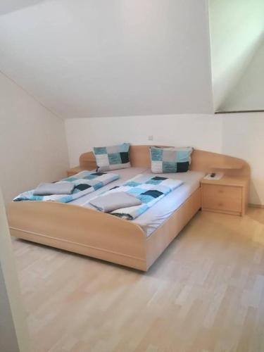 a large bed in a room with a wooden floor at Ein schöner Panorama Blick in Augsdorf