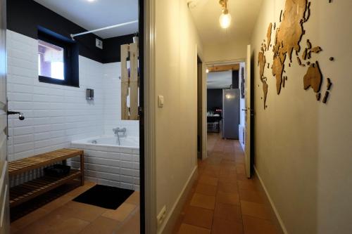a bathroom with a tub and a walk in shower at Mélina - appartement dans les remparts de la Bastide avec parking et terrasse in Carcassonne