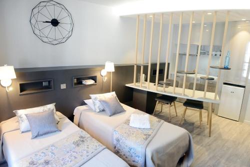 Habitación de hotel con 2 camas y escritorio en La Résidence des Thermes, en Bagnères-de-Bigorre