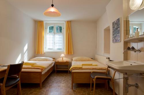 a room with two beds and a sink in it at Parkhotel Emmaus - Casa Rustico in Ascona