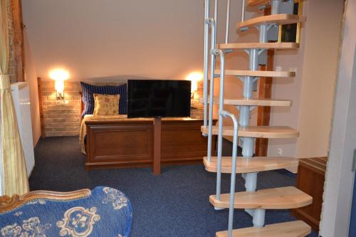a room with a spiral staircase and a living room at Penzion Aurooms in Zlatníky