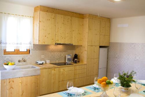 a kitchen with wooden cabinets and a table with a bowl of fruit at Casa do Rabana in Leiria