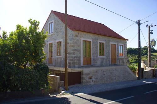 a small stone house with a red roof at Casa do Rabana in Leiria