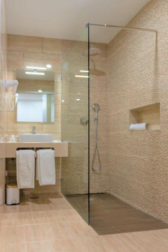 a bathroom with a shower and a sink at Hotel Pinhal do Sol in Quarteira