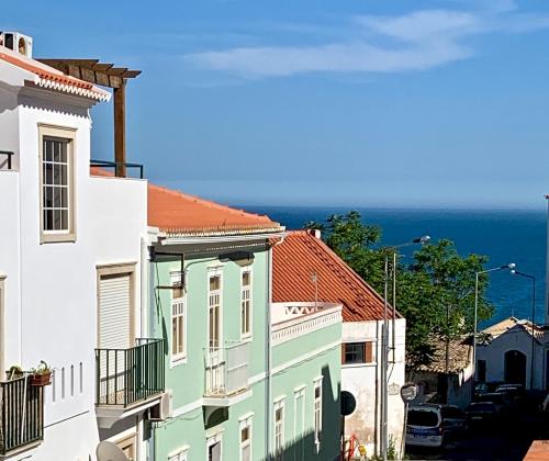 a group of buildings with the ocean in the background at Full private 180sqm Villa - Terrace Jacuzzi - 200m Beach & Sea View in Albufeira